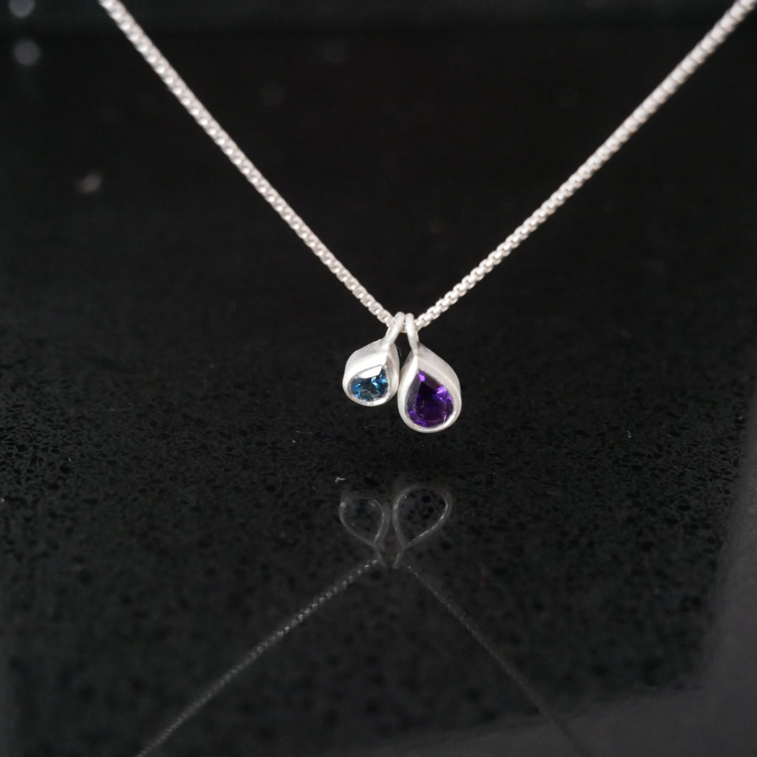 Silver necklace with two teardrop-shaped gemstones