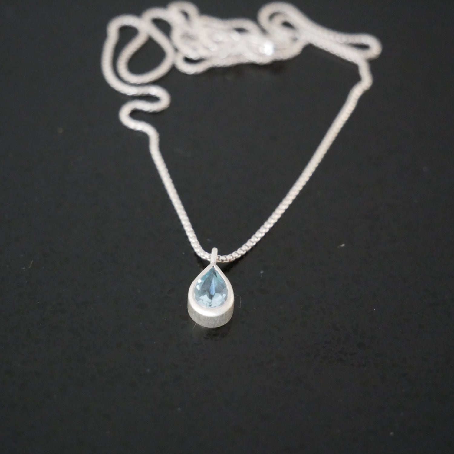 Silver necklace with a teardrop-shaped pendant 