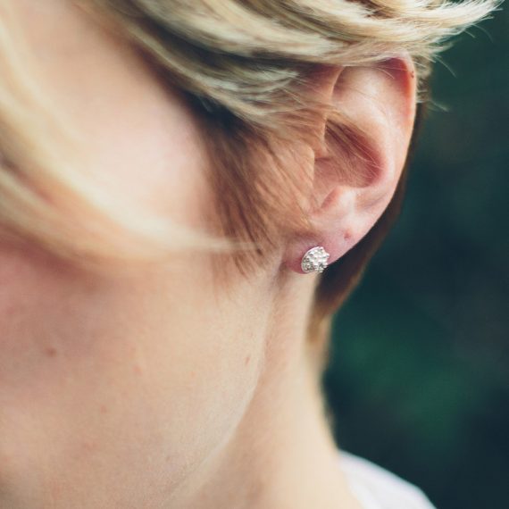 silver tiny beaded stud earring closeup on model