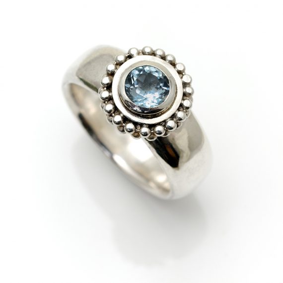 Silver decorative beaded ring with pale blue topaz