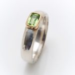 narrow chunky silver ring with rectangular peridot set in 18ct yellow gold